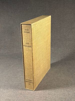 an old book sitting on top of a table on a gray surface