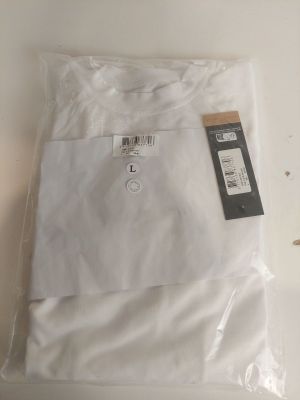 une chemise blanche et une paire de ciseaux posés sur une table