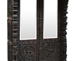 carved wooden armoire with two mirrors on top of it