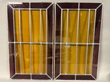 two windows with bars on each of them and a yellow curtain behind them