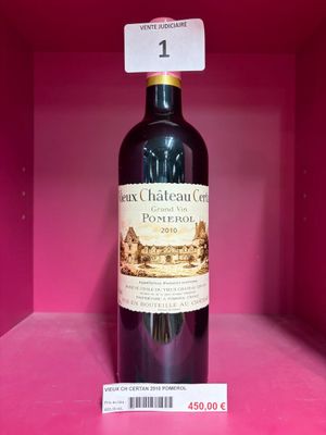 une bouteille de vin posée sur une étagère, dans une boîte rose