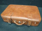 a brown leather suitcase sitting on a black surface