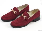une paire de chaussures en daim rouge avec une chaîne dorée au talon