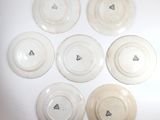 six white plates with butterflies on them sitting on a white surface