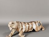 une image représentant une figurine de tigre sur fond gris