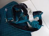 a blue purse with a knot on it sitting on the floor
