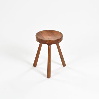 un petit tabouret en bois posé sur une surface blanche