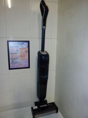un aspirateur noir et argenté posé sur un plan de travail blanc
