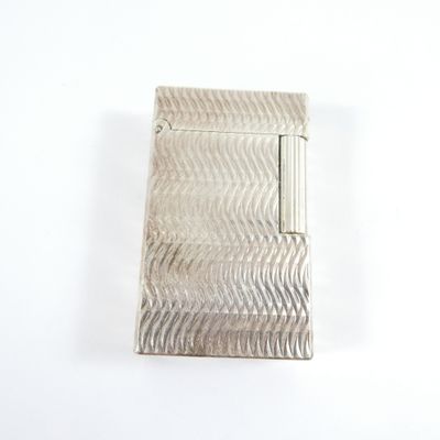 une image représentant un étui à cigarettes argenté posé sur une surface blanche