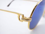 gold and blue sunglasses on a white surface with a white background
