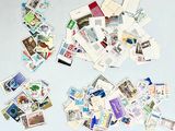 beaucoup de timbres sur la table et une paire de ciseaux