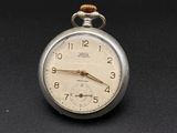 a silver pocket watch sitting on a black surface