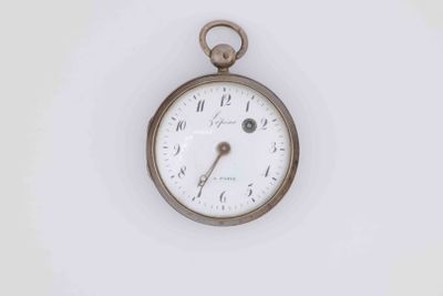 an antique pocket watch on a white surface with a white background