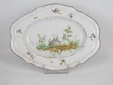 a plate with birds and flowers on it on a stand