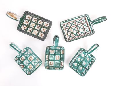 quatre ustensiles de cuisine en céramique verts et blancs posés sur une surface blanche