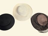 three hats sitting on top of each other on a white surface