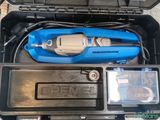 a blue tool in a black case on the floor