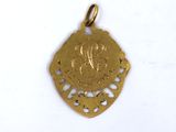 a close up of a gold pendant on a white surface
