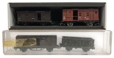 deux petits trains dans une boîte posée sur une surface blanche