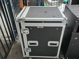 une valise noire et blanche posée par terre à côté d'autres objets