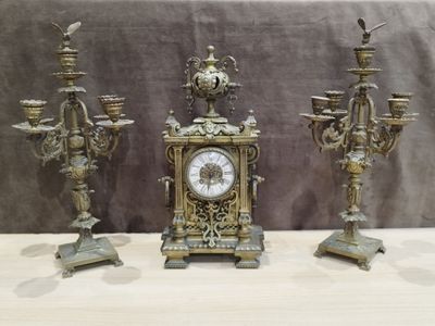 three antique clocks sitting on a table next to each other