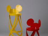 une chaise Mickey Mouse jaune et rouge à côté d'une chaise Mickey Mouse rouge