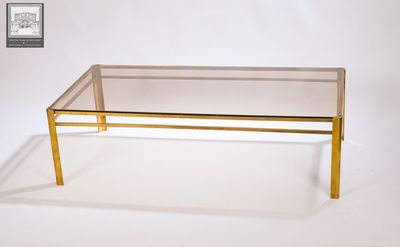 une table basse en verre surmontée d'un cadre doré