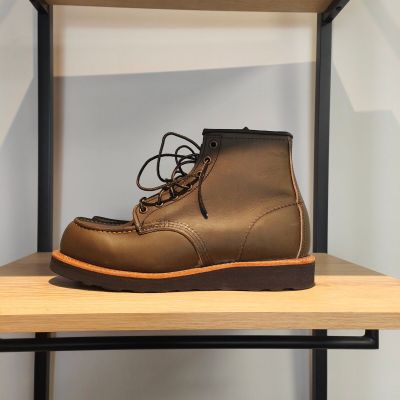une paire de bottes marron posée sur une étagère en bois