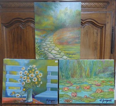 trois tableaux posés sur une table, avec un vase de fleurs