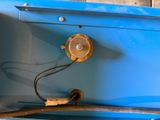 a blue box with a brown handle and a wire on it