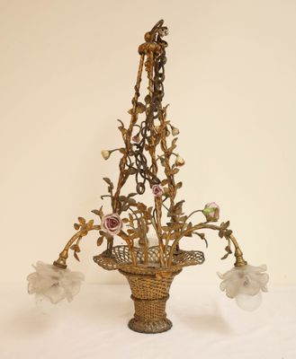 un lustre d'où pendent des fleurs, posé sur une table blanche