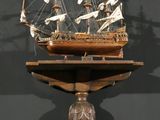 a wooden model of a ship on display on a shelf