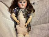 a doll that is laying down on a white sheet