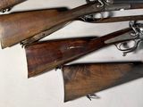 several different types of guns are lined up on a white surface