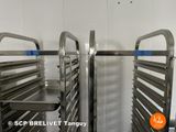 two metal racks with trays on them in a kitchen