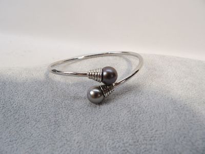 un gros plan d'une bague ornée de deux perles