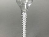 a wine glass with a twisted stem on a table