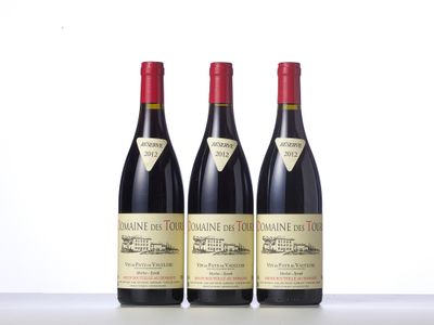 trois bouteilles de vin sont alignées sur une table