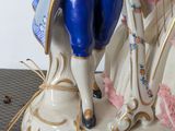 a figurine of a man and a woman playing a musical instrument