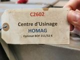 une personne tenant une étiquette sur laquelle est inscrit « homag »