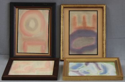 trois tableaux encadrés, de couleurs et de formes différentes, posés sur une table
