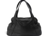 Le grand sac à main noir est posé sur une surface blanche.