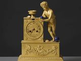 une horloge en or surmontée d'une statue