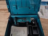 une boîte à outils bleue contenant des outils, posée sur une table en bois