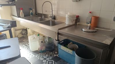 une cuisine équipée d'un évier, d'une cuisinière et d'une poubelle