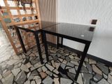a glass table with a black top and a black base