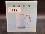 packaging of a blue and white electric kettle sitting on a table