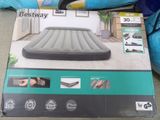 the box of the inflatable air mattress is open on the floor