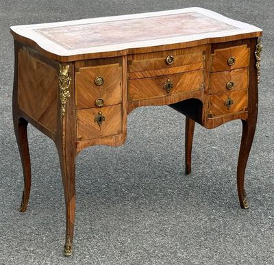 un vieux bureau en bois avec un plateau en marbre et des tiroirs