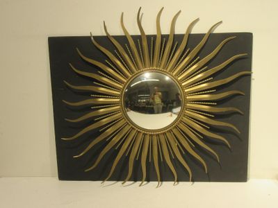 un motif « sunburst » noir et doré orné d'un miroir